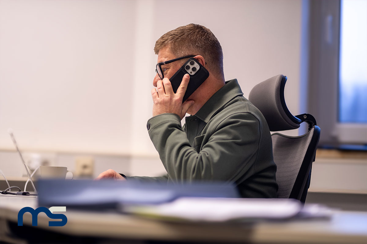 Holger Abeln sitzend an seinem Schreibtisch am Telefon